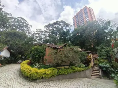 a garden with a small house and a building at Casa Campestre 1 Nivel para 9H , Poblado San Lucas 110 in Medellín