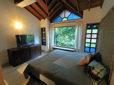 a bedroom with a large bed and a large window at Loft campestre con terraza en el Poblado apt 113 in Medellín