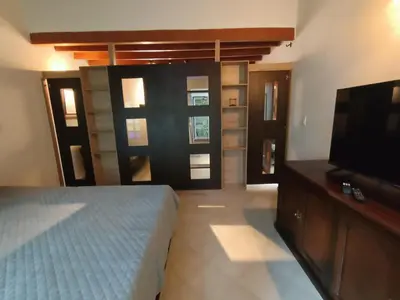 a bedroom with a bed and a flat screen tv at Loft campestre con terraza en el Poblado apt 113 in Medellín