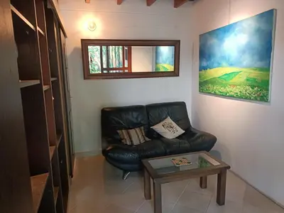 a living room with a leather couch and a table at Loft campestre con terraza en el Poblado apt 113 in Medellín