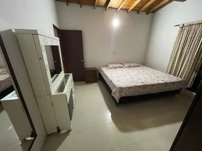 a bedroom with a bed and a dresser and a mirror at Amplio apartamento en Niquia in Bello