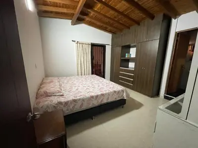 a bedroom with a bed and a wooden cabinet at Amplio apartamento en Niquia in Bello