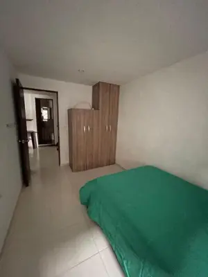 a bedroom with a green bed and a wooden cabinet at Amplio apartamento en Niquia in Bello