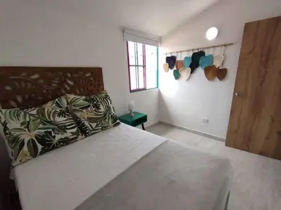 a bedroom with a large bed with a wooden headboard at Apto Nuevo, Tranquilo, Bonito, 5 min Plaza Principal in Guatapé