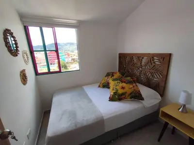a bedroom with a bed and a window at Apto Nuevo, Tranquilo, Bonito, 5 min Plaza Principal in Guatapé