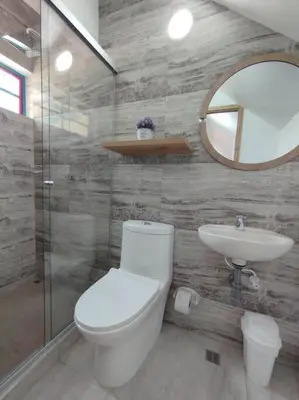 a bathroom with a toilet and a sink and a mirror at Apto Nuevo, Tranquilo, Bonito, 5 min Plaza Principal in Guatapé