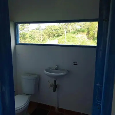 a bathroom with a toilet and a sink and a window at AZULEJO, Casa hotel campestre in Jericó