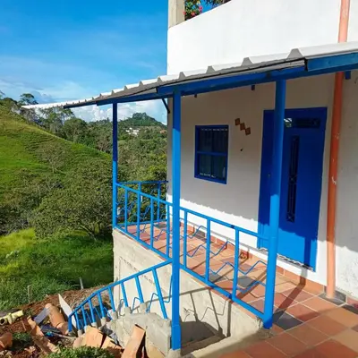 a house with a blue door and a balcony at AZULEJO, Casa hotel campestre in Jericó