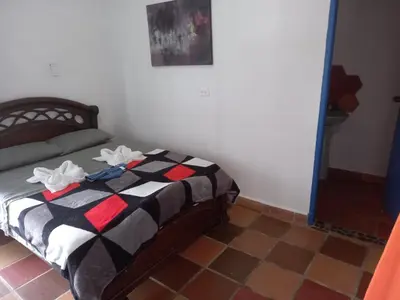 a bedroom with a bed with a black and white blanket at AZULEJO, Casa hotel campestre in Jericó