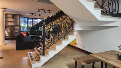 a staircase in a house with a couch and a table at Paisa Hostel Medellín in Medellín