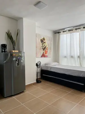 a room with a bed and a refrigerator in it at Laurel de Florida Apto in Medellín