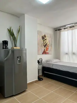 a bedroom with a bed and a refrigerator in it at Laurel de Florida Apto in Medellín