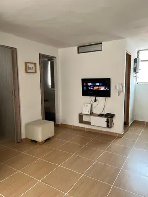 a living room with a television and a tiled floor at Laurel de Florida Apto in Medellín