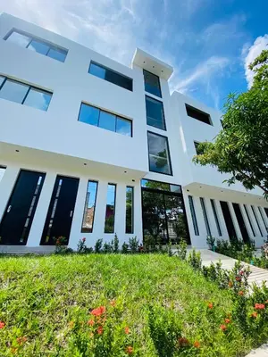 a white building with windows and a lawn at Hotel La Casona San Sebastian in Doradal
