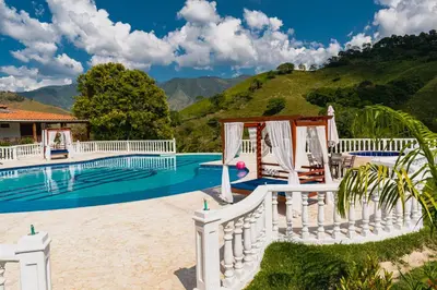a villa with a swimming pool and a fence at Hotel Campestre La Francesina in Betania