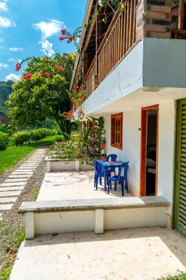 a patio with two blue chairs and a table at Hotel Campestre La Francesina in Betania
