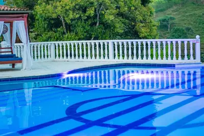 a swimming pool with a white fence and a bench at Hotel Campestre La Francesina in Betania