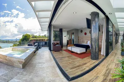 a master bedroom with a view of a bed and a tub at Vivanti Resort in Guatapé