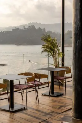 two tables and chairs with a view of the water at Vivanti Resort in Guatapé