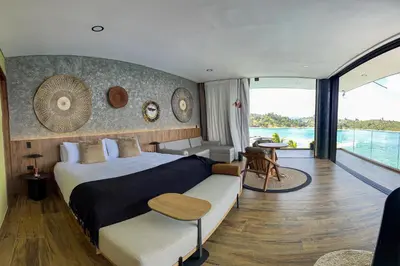 a bedroom with a large bed and a balcony at Vivanti Resort in Guatapé