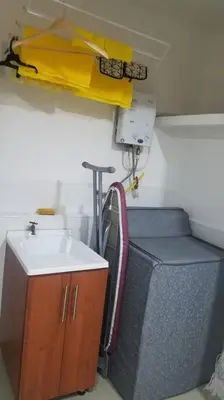 a room with a sink and a chair and a crane at Hospedajes Pilarica in Medellín