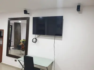 a flat screen tv on a wall next to a mirror at Hospedajes Pilarica in Medellín