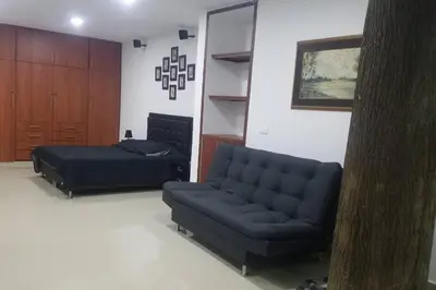 a living room with a couch and a bed at Hospedajes Pilarica in Medellín