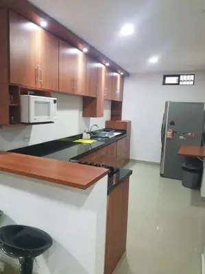 a kitchen with a counter and a microwave and a refrigerator at Hospedajes Pilarica in Medellín