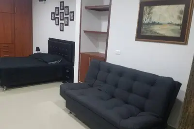 a living room with a couch and a bed at Hospedajes Pilarica in Medellín