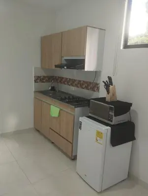 a kitchen with a white refrigerator and a stove at Hospedajes Pilarica in Medellín