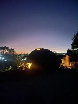 a person sitting in the dark looking at the sunset at Vitta Glamping in Rionegro