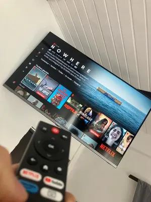 a person holding a remote control in front of a tv at Hostal Del Cielo in Medellín