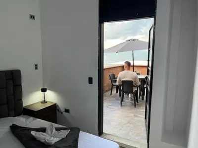a man sitting at a table with an umbrella at Hostal Del Cielo in Medellín