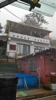 a house with a roof on top of it at Casita el mirador solo naturaleza in Medellín