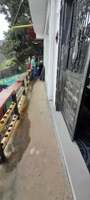 a person sitting on a bench outside of a building at Casita el mirador solo naturaleza in Medellín