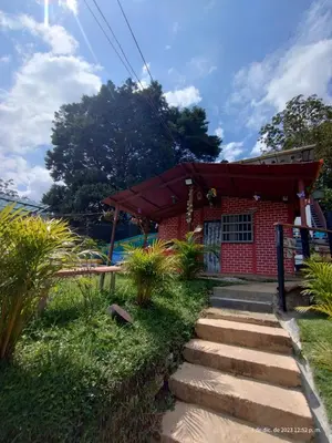 a small red brick building with a path leading to it at Casita el mirador solo naturaleza in Medellín