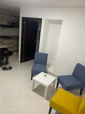 a room with two chairs and a table and a door at Apartamentos amueblados, zona céntrica-Cisneros- antioquia in Cisneros