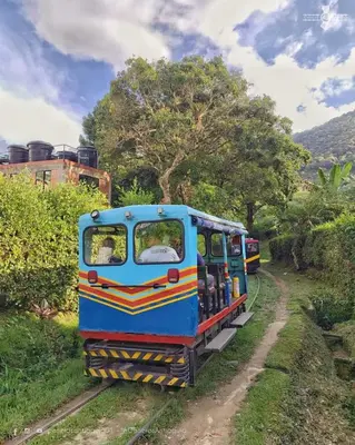 a blue train is on the tracks at Apartamentos amueblados, zona céntrica-Cisneros- antioquia in Cisneros
