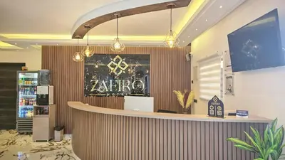 a restaurant with a bar with a sign on the wall at ZAFIRO HOTEL in Doradal