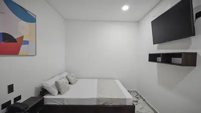 a white room with a bed and a tv at ZAFIRO HOTEL in Doradal