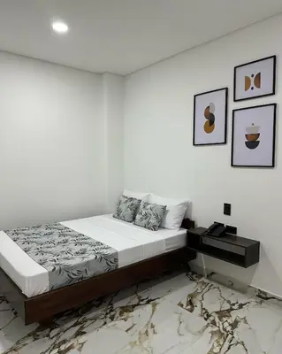 a bedroom with a bed and a white wall at ZAFIRO HOTEL in Doradal