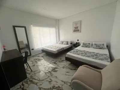 a bedroom with two beds and a mirror at ZAFIRO HOTEL in Doradal