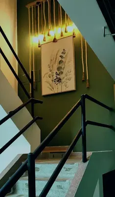 a staircase with a picture on a green wall at HOTEL BOHO BOUTIQUE in Quibdó