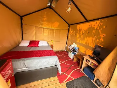 a bedroom with a bed in a tent at Glamping Colibrí, bosque vecino y vista a la montaña al mismo tiempo in Jardin