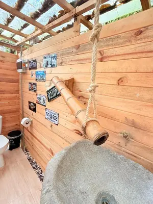 a log hanging from a wall in a bathroom at Glamping Colibrí, bosque vecino y vista a la montaña al mismo tiempo in Jardin