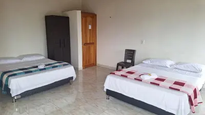 a bedroom with two beds and a door in it at HOSPEDAJE VILLA SAMARA --- cerca de la piedra -- GUATAPÉ in Guatapé