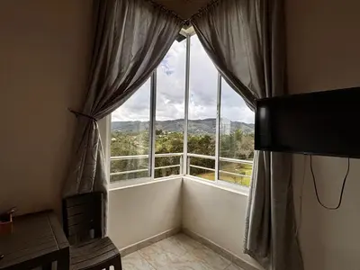 a room with a large window with a mountain view at HOSPEDAJE VILLA SAMARA --- cerca de la piedra -- GUATAPÉ in Guatapé