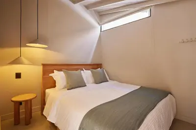 a small bedroom with a bed and a window at Antipoda Hotel Boutique in Medellín