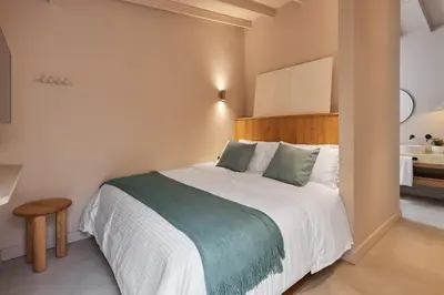 a bedroom with a large bed with a wooden headboard at Antipoda Hotel Boutique in Medellín