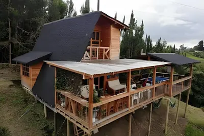a house with a metal roof on top of it at Cabaña Entre Aguacates, Refugio en Marinilla in Marinilla